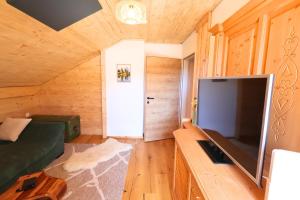 a living room with a large flat screen tv at Claras Bergzeit in Flattnitz
