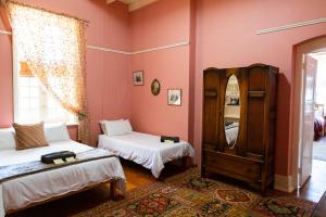 a bedroom with two beds and a mirror at The Manor House at Dunn's Castle in Piketberg