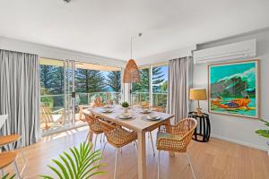 a dining room with a table and chairs at Pacific Regis Beachfront Holiday Apartments in Gold Coast