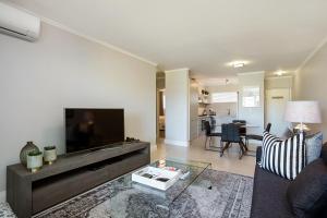 uma sala de estar com um sofá e uma televisão em Apartments on Century em Cidade do Cabo