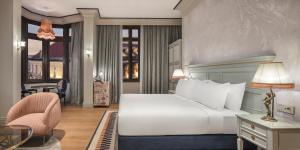 a bedroom with a bed and a desk and a chair at Palazzo Donizetti Istanbul, Tapestry Collection by Hilton in Istanbul