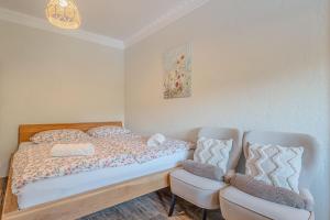 a bedroom with a bed and two chairs at Vila Trate with Shared Pool and Garden in Ljutomer