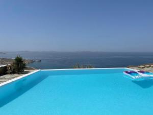 a blue swimming pool with a view of the ocean at Luxury Villa Dorothea Mykonos in Fanari