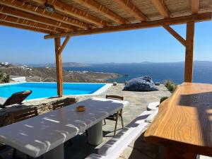 a patio with a table and a view of the ocean at Luxury Villa Dorothea Mykonos in Fanari