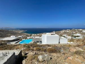 a building on top of a hill next to the ocean at Luxury Villa Dorothea Mykonos in Fanari