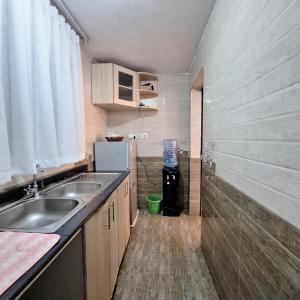 a small kitchen with a sink and a refrigerator at Zerani Homes in Ruaka
