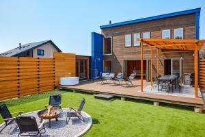a backyard with chairs and a table and a house at IZA moriyama in Moriyama