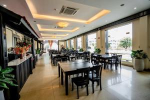 a dining room with tables and chairs in a restaurant at Hung Long Harbour Hotel in Cat Ba