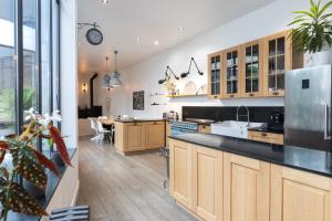a large kitchen with wooden cabinets and a counter top at Villa cosy Paris in La Garenne-Colombes