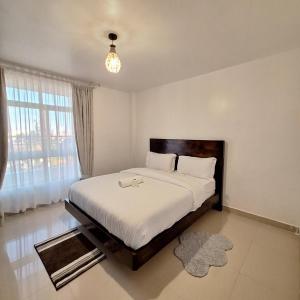 a bedroom with a large bed with a large window at Zerani Homes in Ruaka