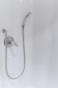 a shower with a mirror on a white wall at Ibis Budget Le Havre Les Docks in Le Havre +44 photos