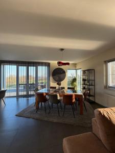 a living room with a dining room table and chairs at Le Daguet pour 8 in Florenville