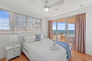 a bedroom with a white bed and a balcony at Pacific Regis Beachfront Holiday Apartments in Gold Coast +168 photos