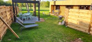 a backyard with a table and chairs and a grill at Gîte de charme Ò Chalet in Camors