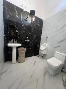 a bathroom with a toilet and a sink at Hotel Plain A Quiet Stay in Mubārikpur