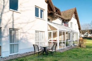 a patio with chairs and a table in front of a building at Strandhaus Lobbe, Sanddorn Nr 3 - Bade- & Saunawelt täglich inklusive in Lobbe