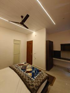 a bedroom with a bed and a ceiling fan at Hotel Plain A Quiet Stay in Mubārikpur