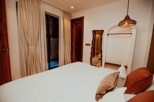 a bedroom with a white bed and a window at Nook Villas in Bagamoyo +18 photos