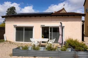 a house with a table and chairs in front of it at La Maisonette à Lacrost in Lacrost