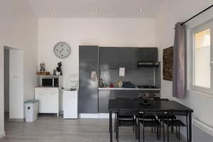 a kitchen with a table and chairs and a clock on the wall at La Maisonette à Lacrost in Lacrost