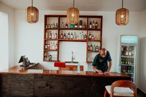 a man standing at a counter in a bar at Nook Villas in Bagamoyo