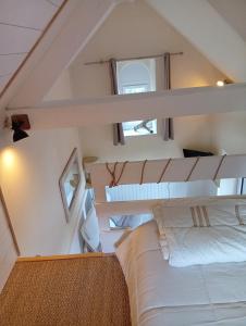 an attic bedroom with a bed and two windows at Lili de La LisaThi in Cruéjouls +39 photos