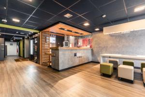 a restaurant with a counter and chairs in a room at Ibis Budget Le Havre Les Docks in Le Havre