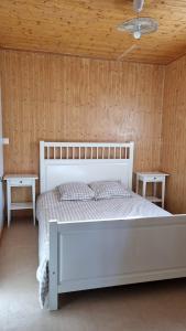 a bedroom with a white bed and two tables at Les Chalets de la Besbre in Jaligny