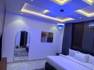 a bedroom with a large bed and a mirror at De Ark Inn hotel in Port Harcourt