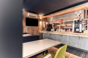 a restaurant with a table and chairs and a counter at Ibis Budget Le Havre Les Docks in Le Havre