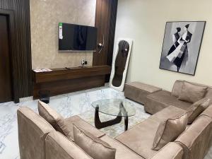 a living room with a couch and a tv at De Ark Inn hotel in Port Harcourt