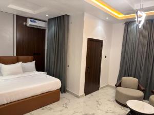 a hotel room with a bed and a chair at De Ark Inn hotel in Port Harcourt
