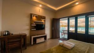 a bedroom with a bed and a desk and a television at Willostays Tamarind beach villa in Cherai Beach