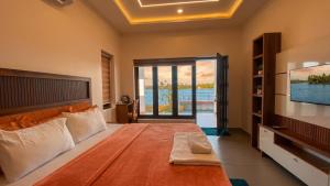 a bedroom with a large bed and a television at Willostays Tamarind beach villa in Cherai Beach
