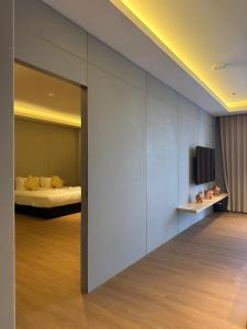 a room with a bed and a television on a wall at Roxy Hotel & Apartment Lawas in Lawas