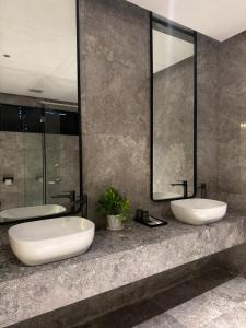 a bathroom with two sinks and a large mirror at Roxy Hotel & Apartment Lawas in Lawas +59 photos