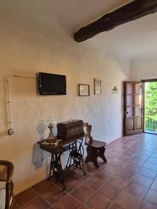 ein Wohnzimmer mit einem Tisch und einem Fernseher an der Wand in der Unterkunft Il Giarolo in Cameriano