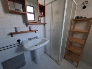 a white bathroom with a sink and a shower at Le Villette Li Sarruni by SalentoInVacanzaCOM in Lido Marini