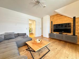 a living room with a couch and a large television at Charly`s Place in Rain