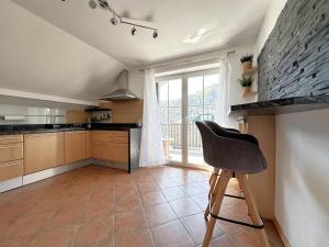 a kitchen with a chair and a large window at Charly`s Place in Rain