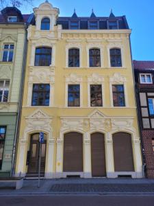 a yellow building with many windows on a street at Lioba in Ueckermünde