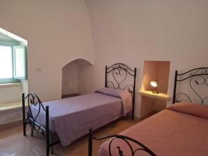 a bedroom with two beds and a window at Le Villette Li Sarruni by SalentoInVacanzaCOM in Lido Marini