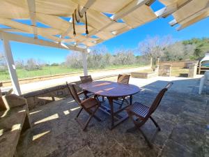 a table and chairs under an umbrella on a patio at Le Villette Li Sarruni by SalentoInVacanzaCOM in Lido Marini +69 photos