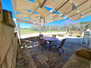 a patio with a table and chairs under a pergola at Le Villette Li Sarruni by SalentoInVacanzaCOM in Lido Marini