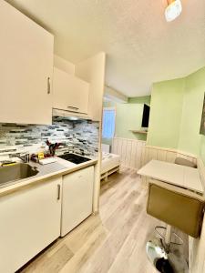 a kitchen with white cabinets and a sink at Harmonieux - Studio - Centre Ville in Tarbes