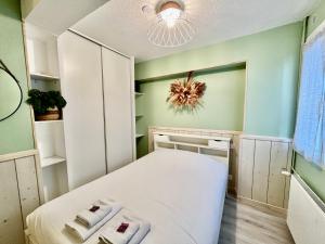 a small bedroom with a white bed and a chandelier at Harmonieux - Studio - Centre Ville in Tarbes