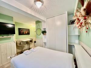 a bedroom with a white bed and green walls at Harmonieux - Studio - Centre Ville in Tarbes