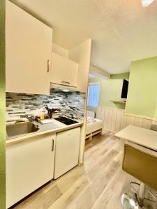 a kitchen with white cabinets and a sink at Harmonieux - Studio - Centre Ville in Tarbes +17 photos