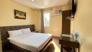 a hotel room with a bed and a desk and a bed sidx sidx sidx sidx at Hotel 801 in Cagayan de Oro