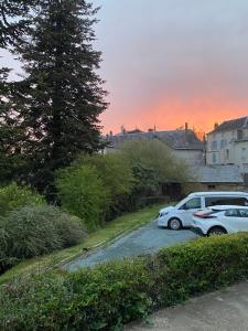two cars parked in a parking lot at sunset at Studio vintage in Parthenay